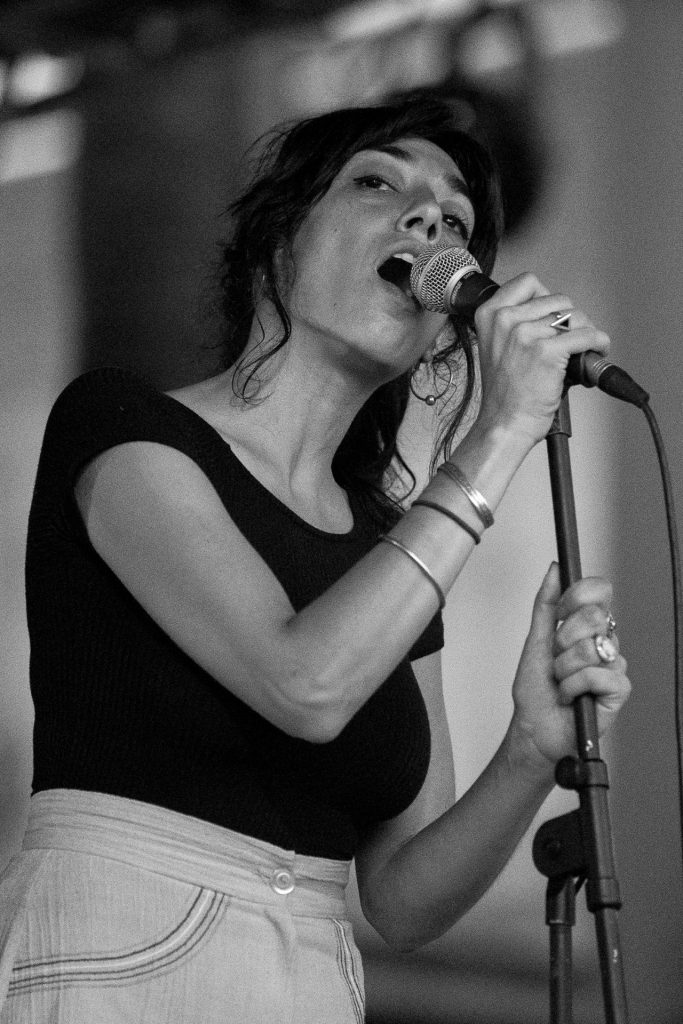 Black-and-white portrait of a female singer performing at the microphone at Oh So Slow