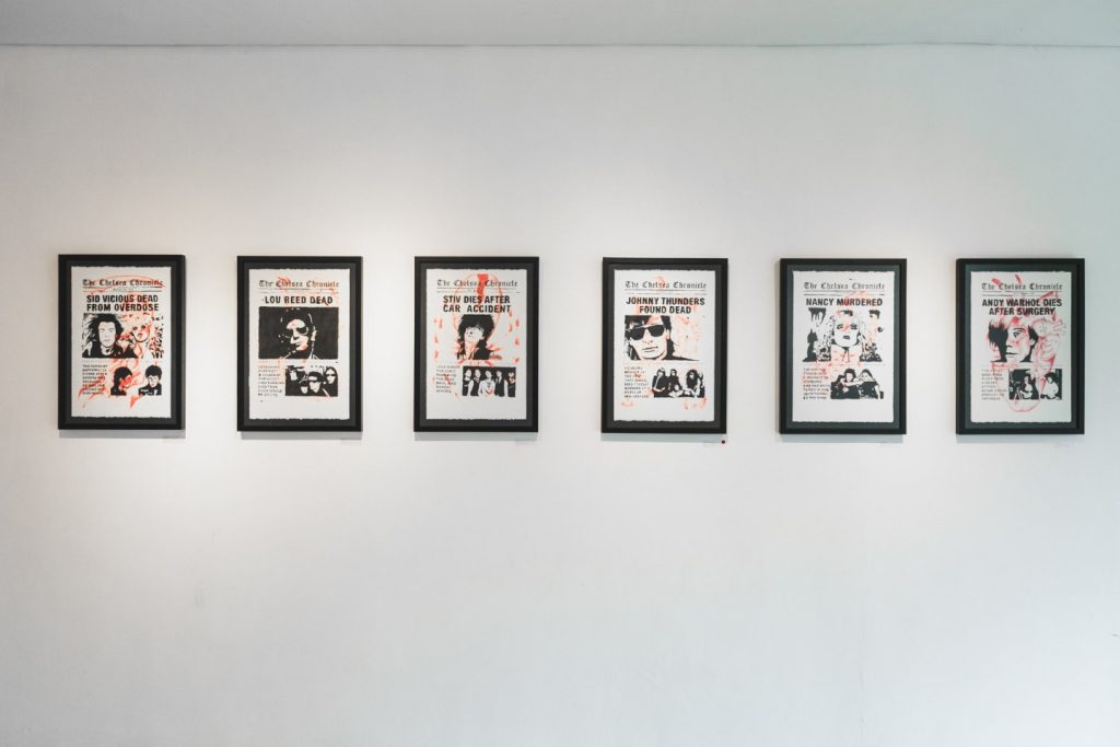 Row of six framed Chelsea Chronicle headline prints by Spiderxdeath on a white gallery wall